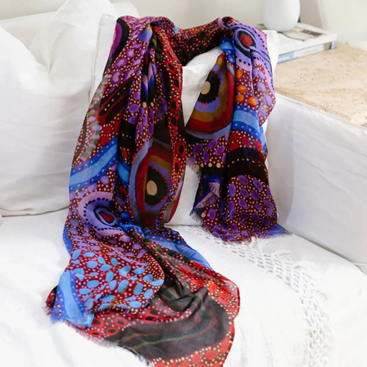 Colorful patterned scarf draped over a white couch
