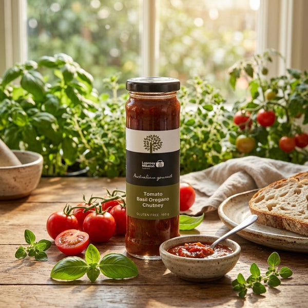 Jar of tomato basil oregano chutney on a wooden table with fresh ingredients and a window view.