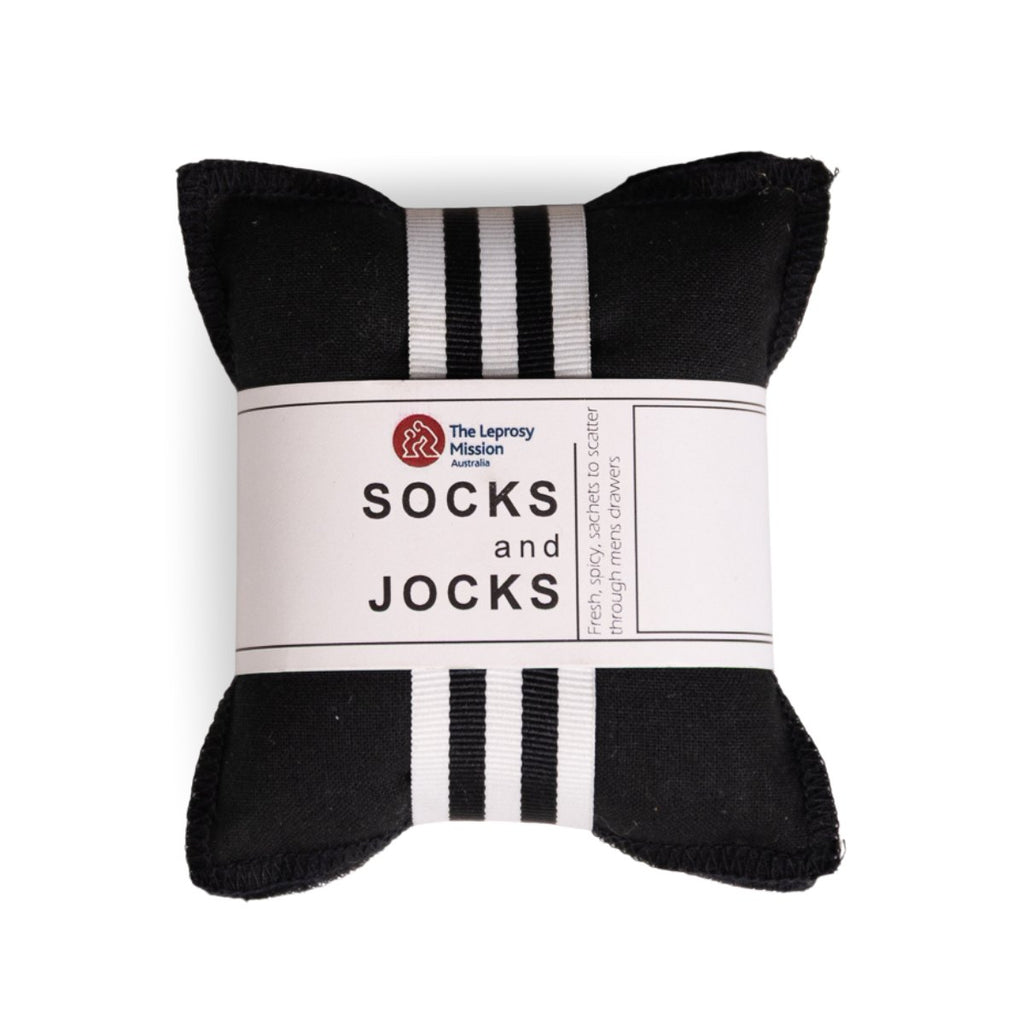 A black sock-shaped gift bag or pouch with white stripes at the top and bottom, wrapped in a white paper band that reads 'The Leprecha Mission Australia SOCKS and JOCKS'.