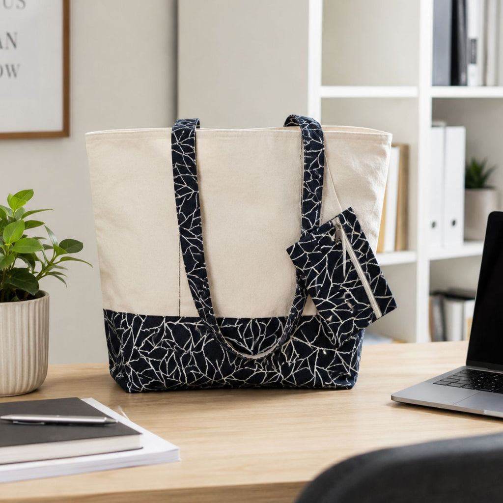 Tote bag with black and white pattern on a desk with a laptop and plant