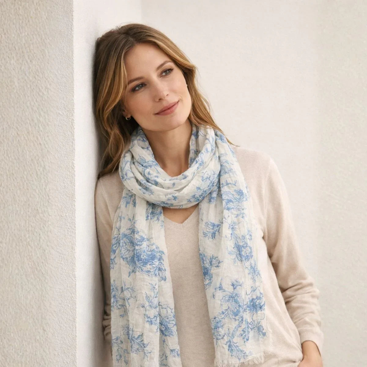 Woman wearing a blue floral scarf against a plain background