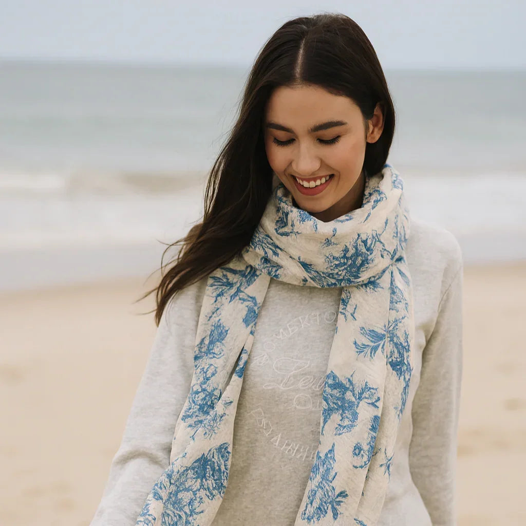 Woman wearing a blue floral scarf in a neutral setting