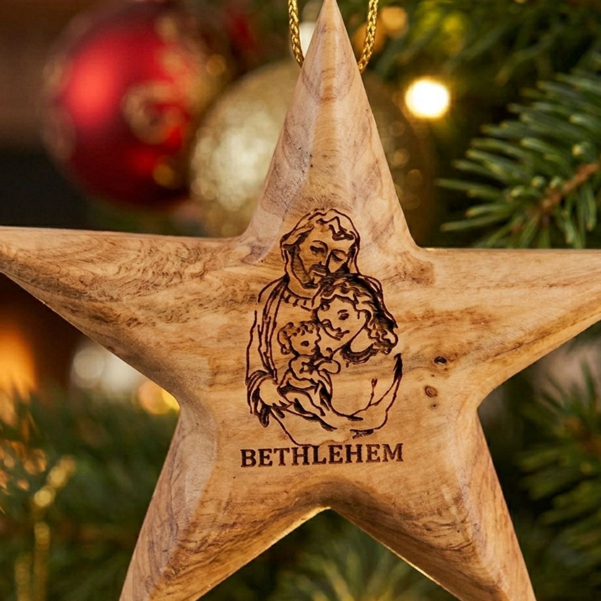 Wooden star ornament with engraved design and 'Bethlehem' text on a Christmas tree.