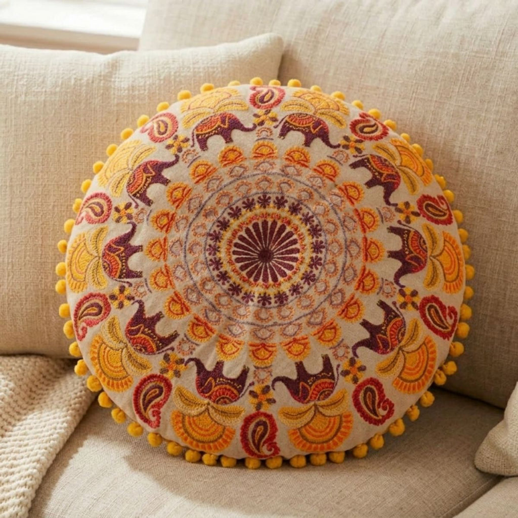 Decorative round pillow with elephant pattern on a beige sofa