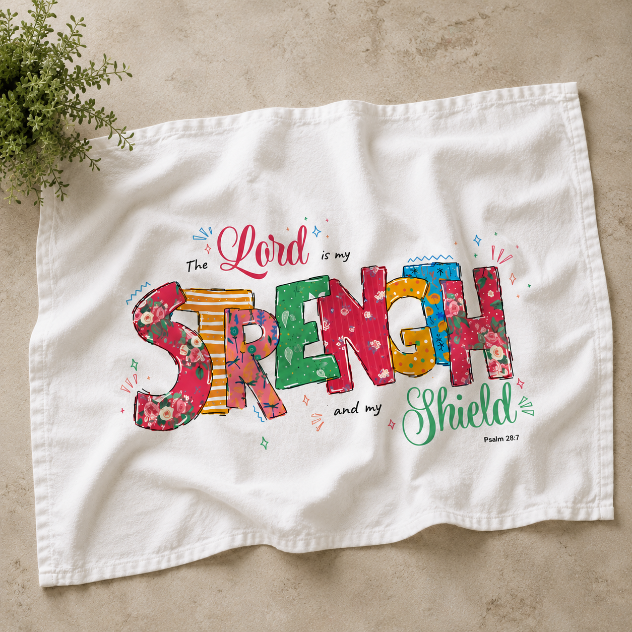 White towel with colorful text design on a beige surface