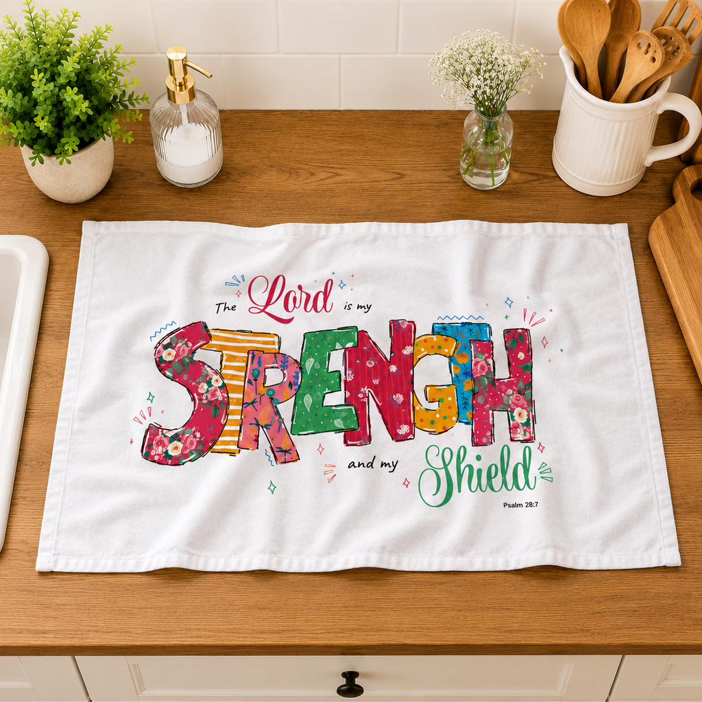 Colorful 'The Lord is my Strength and my Shield' towel on a kitchen counter.