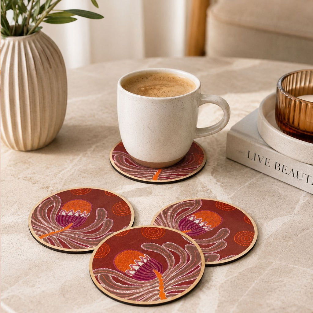 Set of four decorative coasters with a cup of coffee on a table.