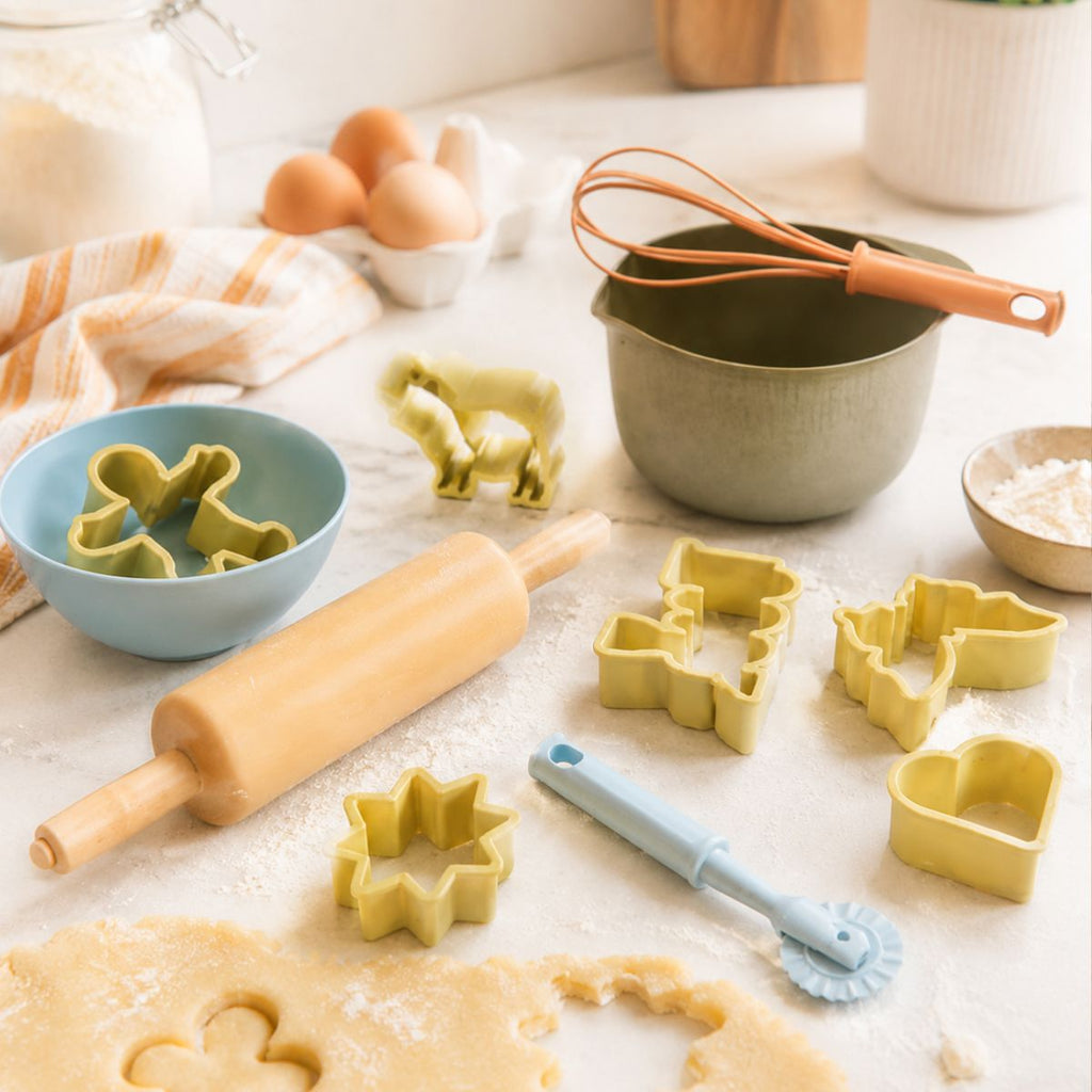 Baking tools and ingredients on a countertop including cookie cutters, rolling pin, and whisk.
