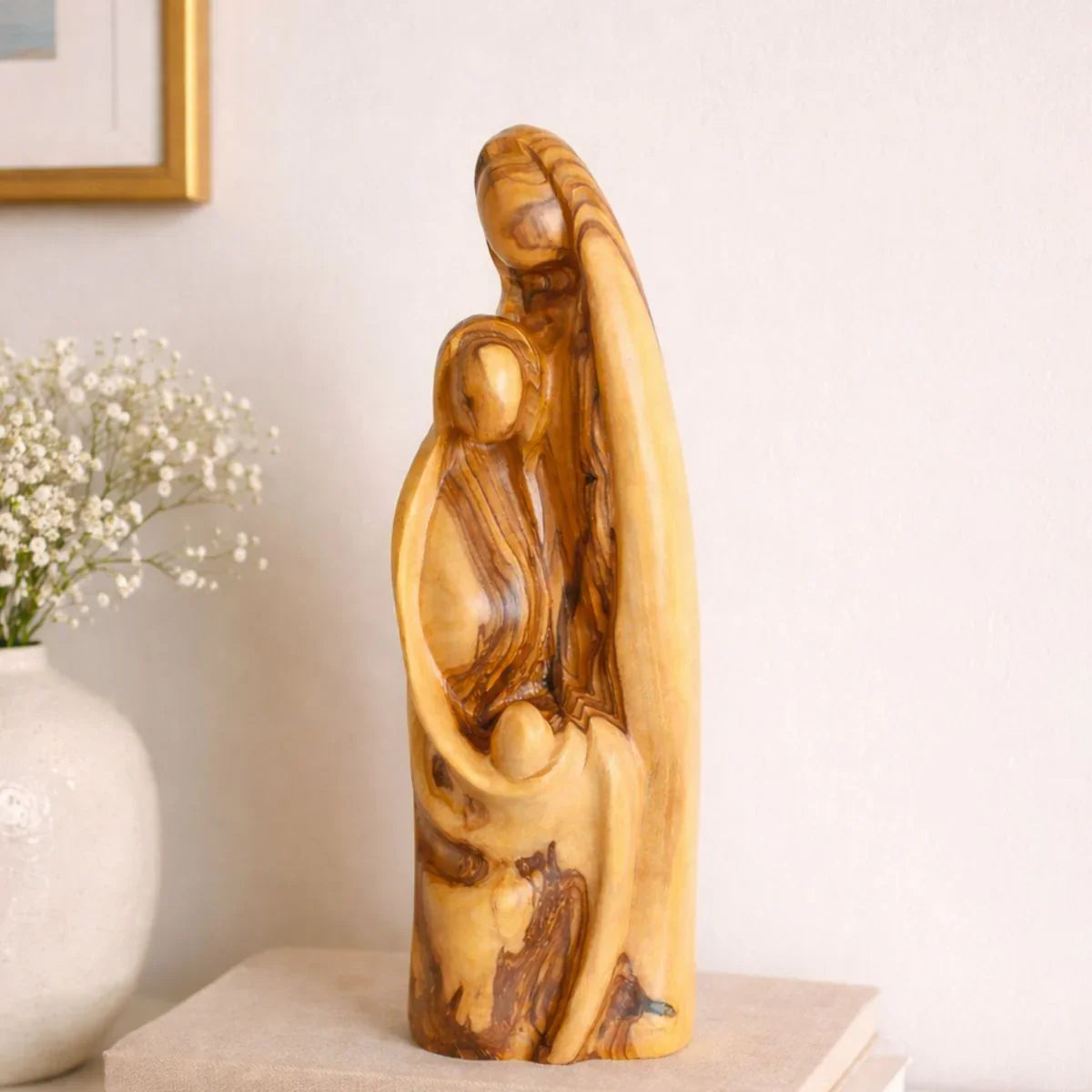 Wooden sculpture of a family on a table with a light background