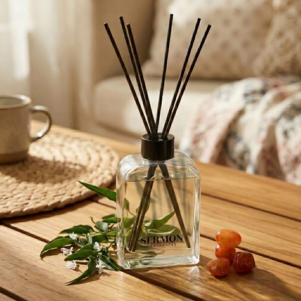 Diffuser with sticks on a wooden table with a cup and decorative stones.