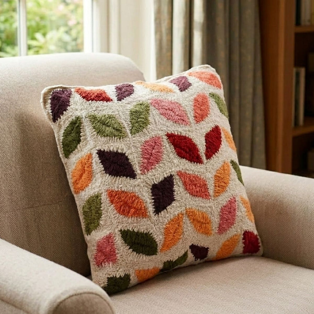 Decorative pillow with leaf pattern on a beige armchair
