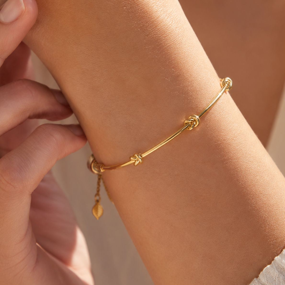 Gold bracelet on a wrist with a blurred background