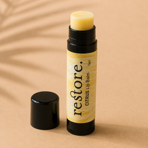 Lip balm stick with 'restore' branding on a beige background