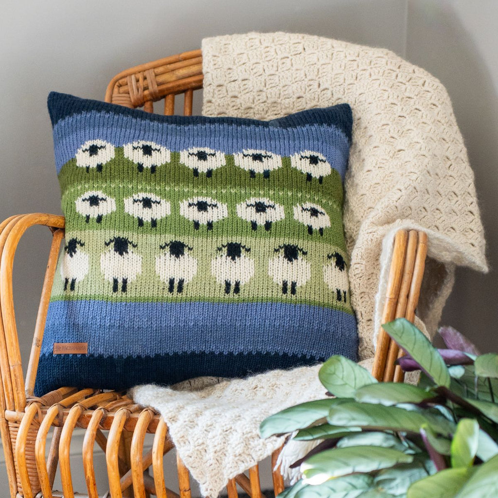 Decorative pillow with sheep pattern on a wicker chair