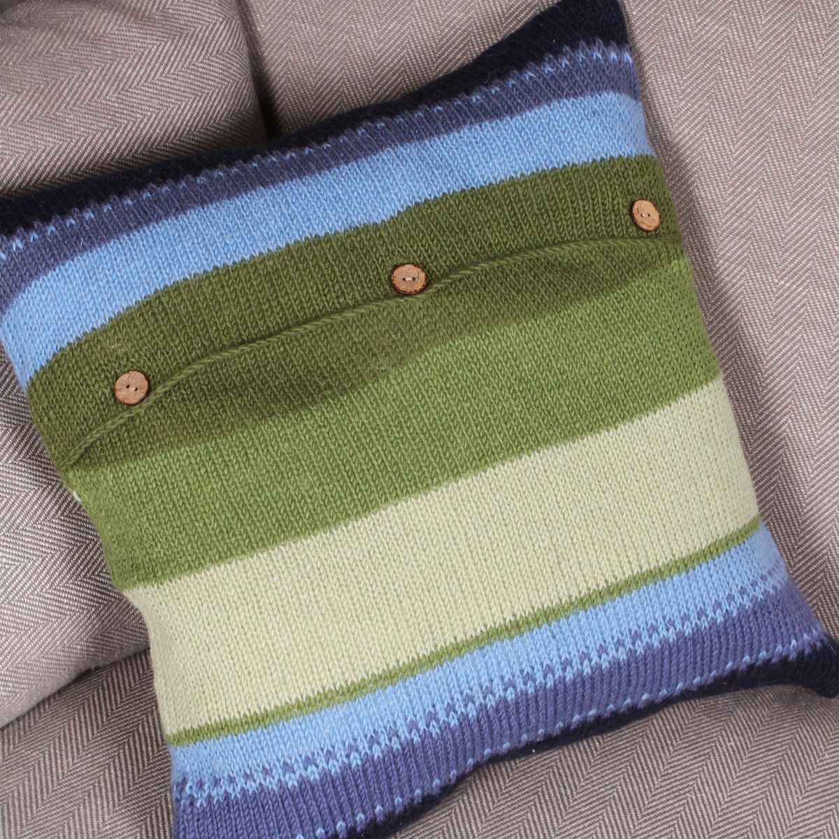 Striped knitted pouch with buttons on a textured fabric background