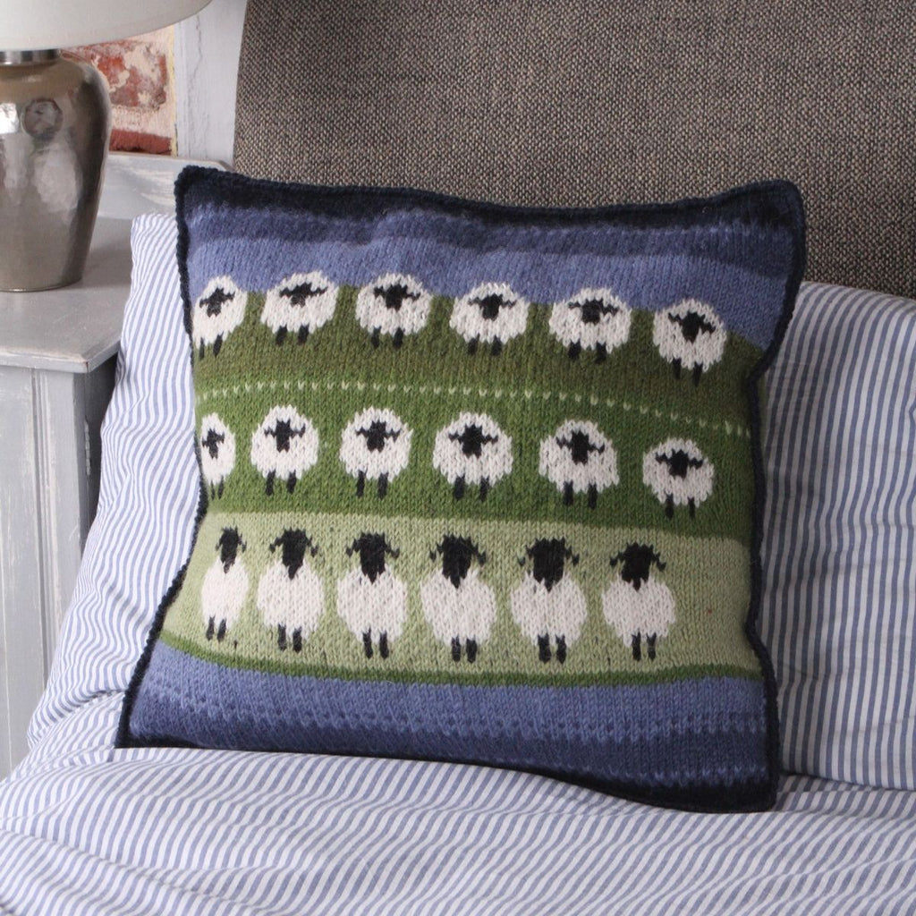 Decorative pillow with sheep pattern on a striped sofa