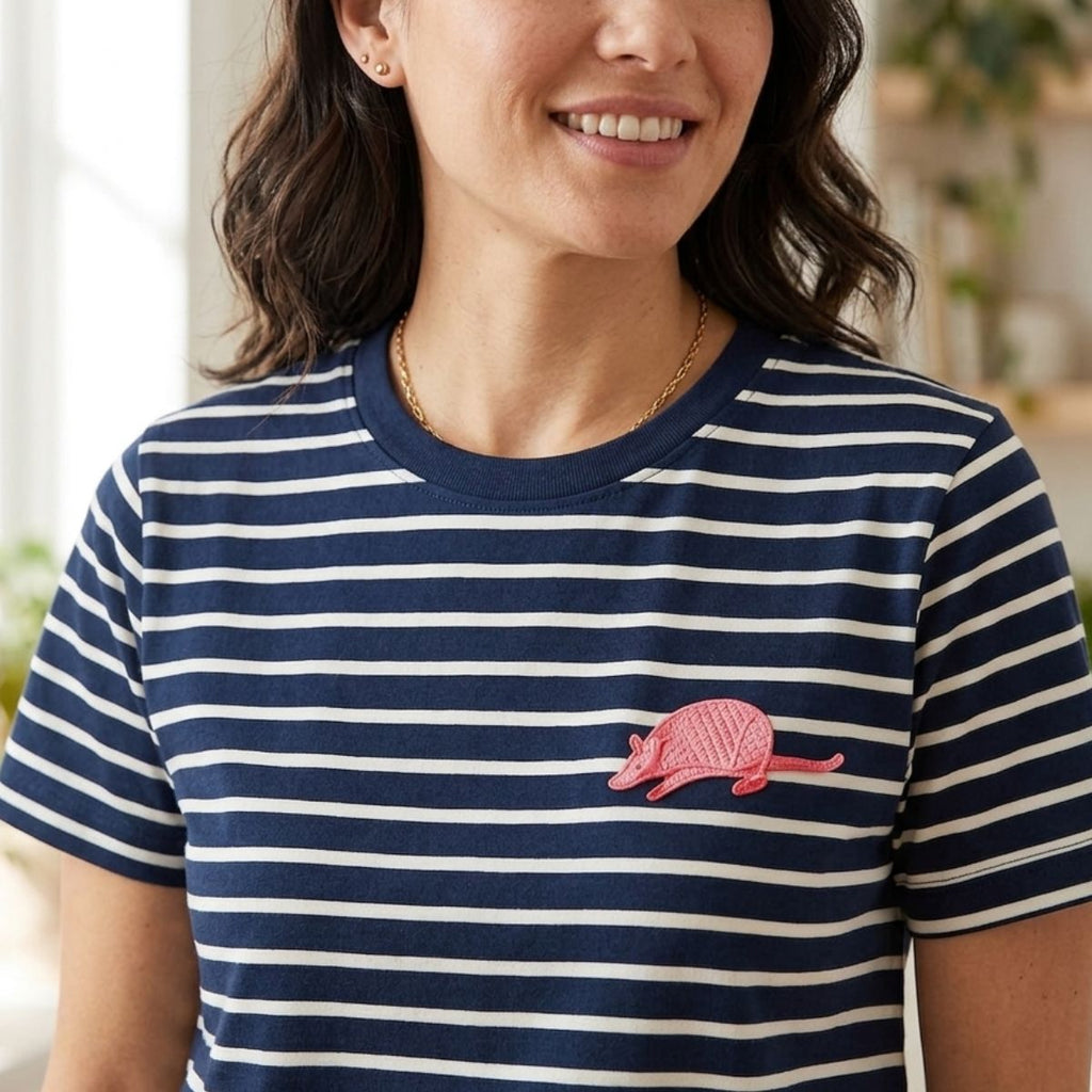 Woman wearing a navy and white striped shirt with an embroidered armadillo design.