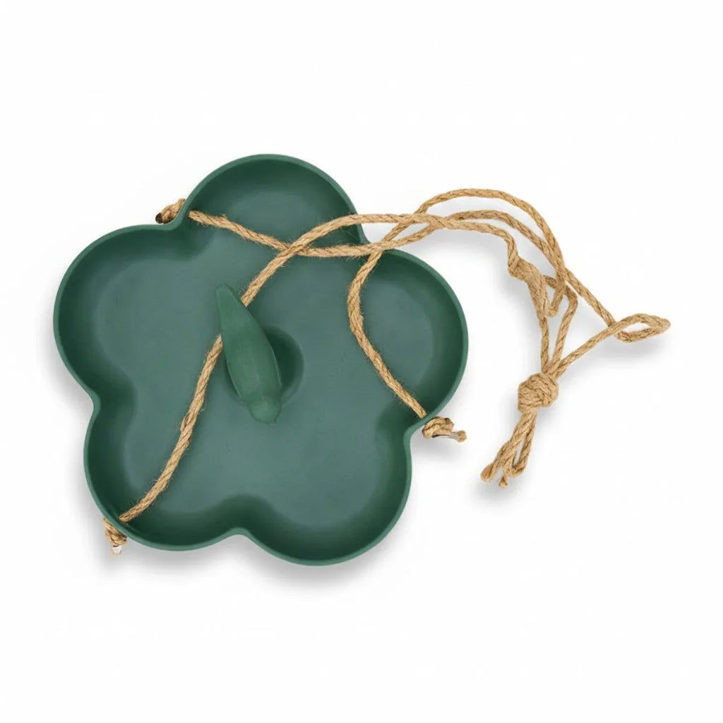 Green leaf-shaped dish with a string on a white background
