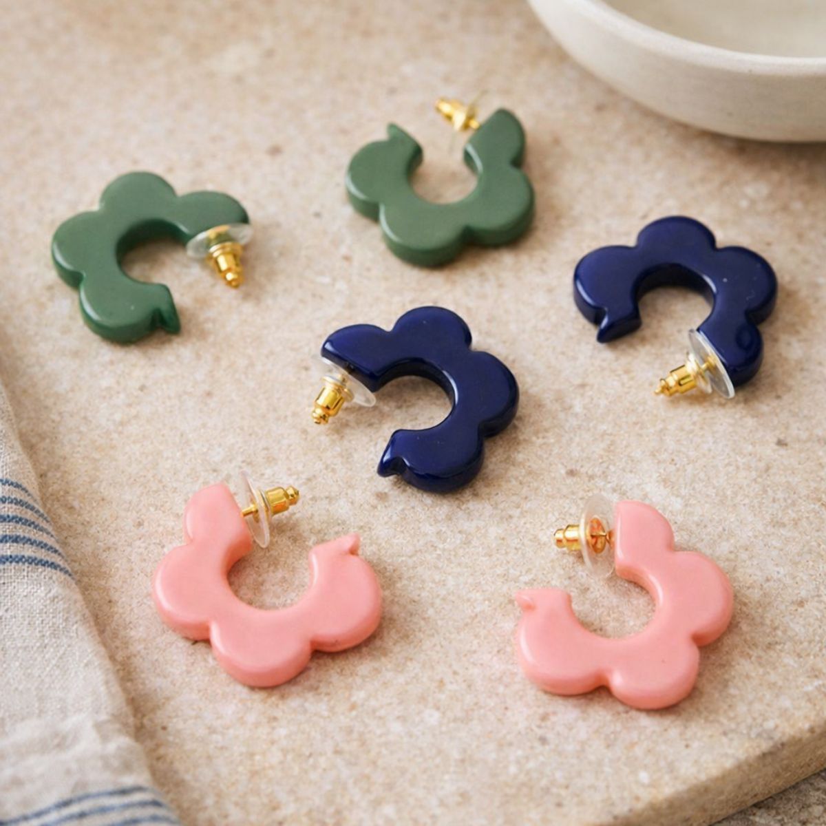 Set of colorful hoop earrings on a textured surface