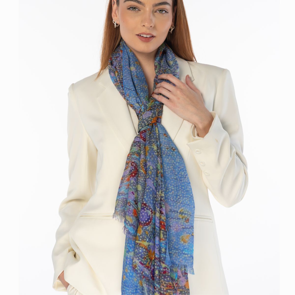 Woman wearing a colorful scarf with a white jacket on a white background