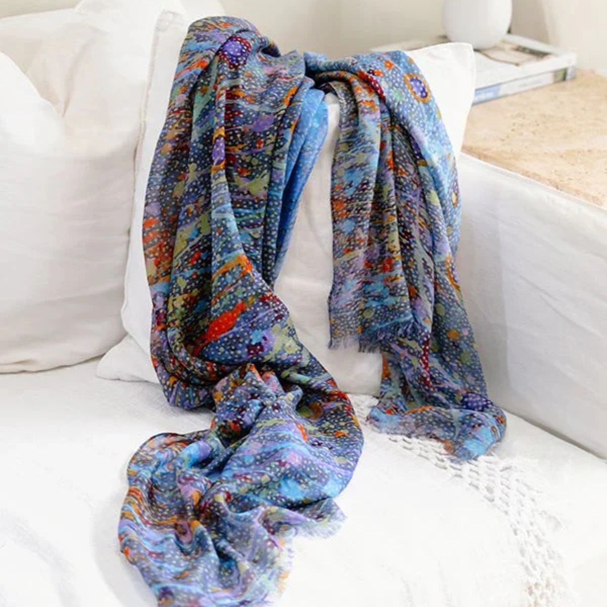 Colorful patterned blanket draped over a white couch