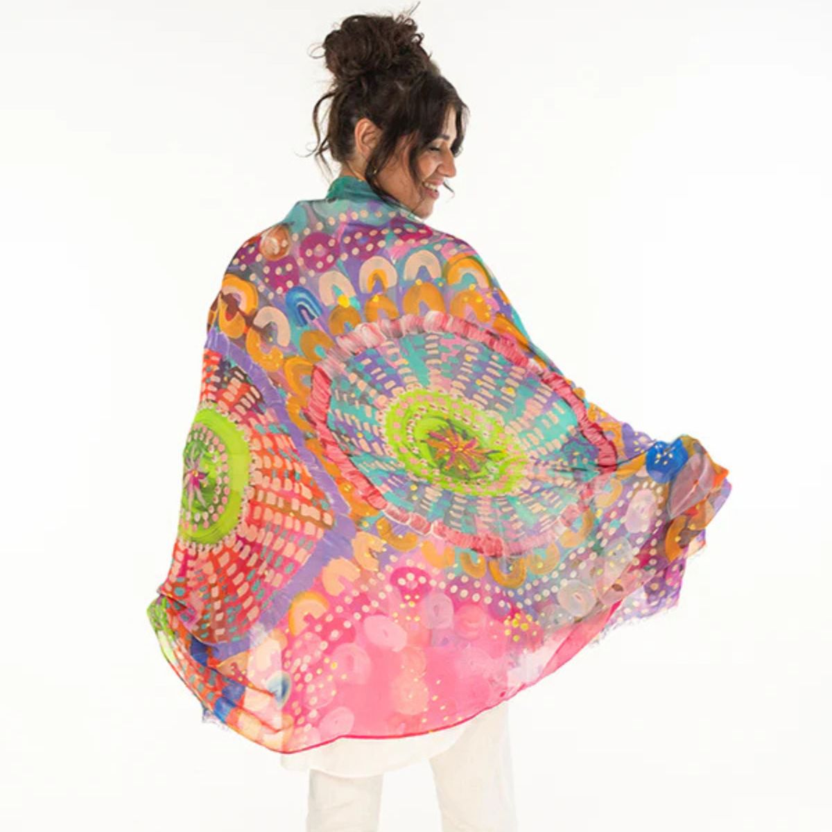 Woman wearing a colorful mandala-patterned scarf on a white background
