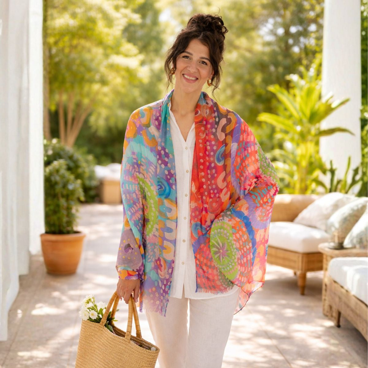 Woman wearing a colorful scarf outdoors in a garden setting