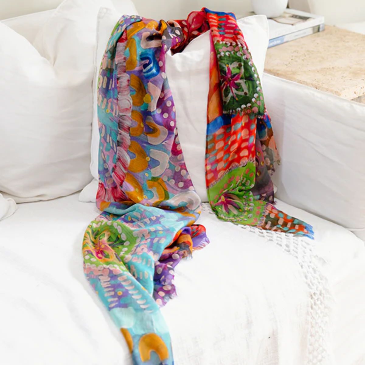 Colorful patterned scarf draped over a white couch