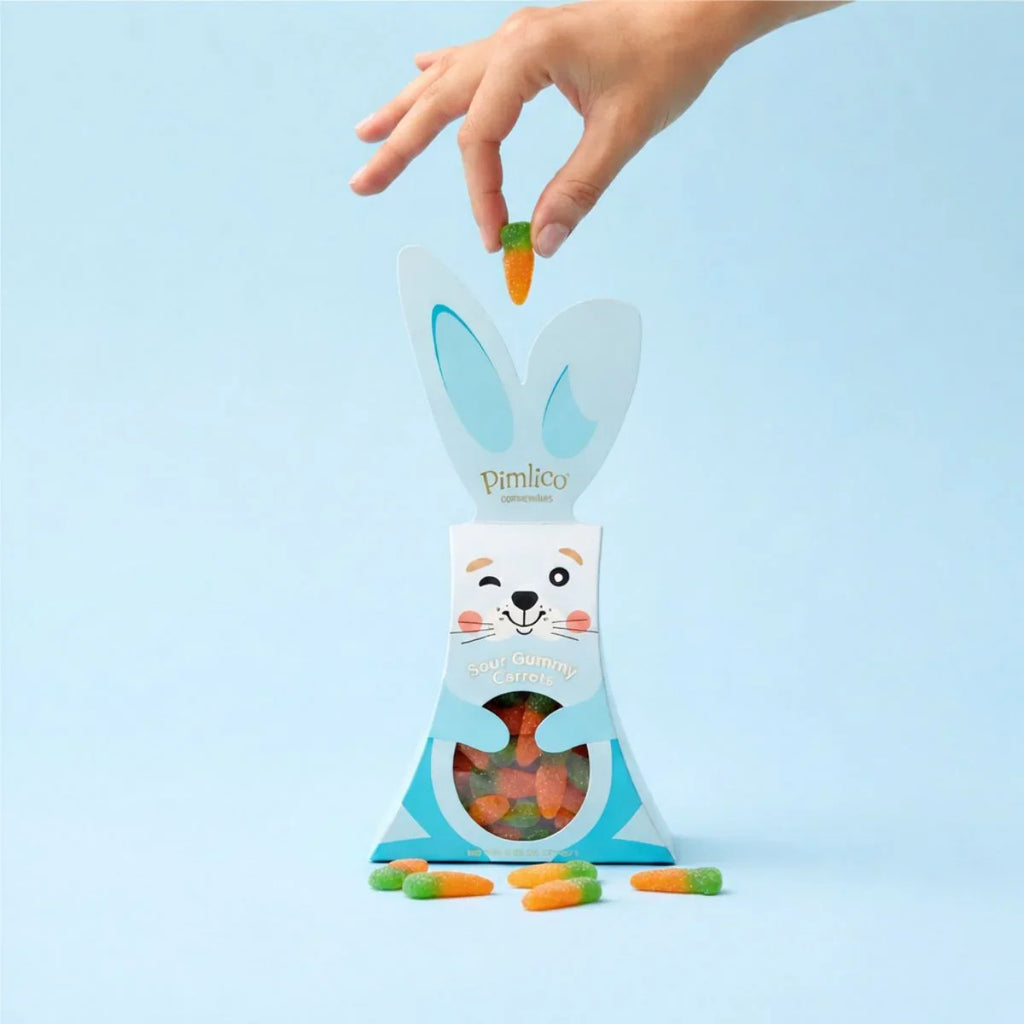 Pimlico rabbit-shaped candy bag with a hand holding a carrot against a light blue background