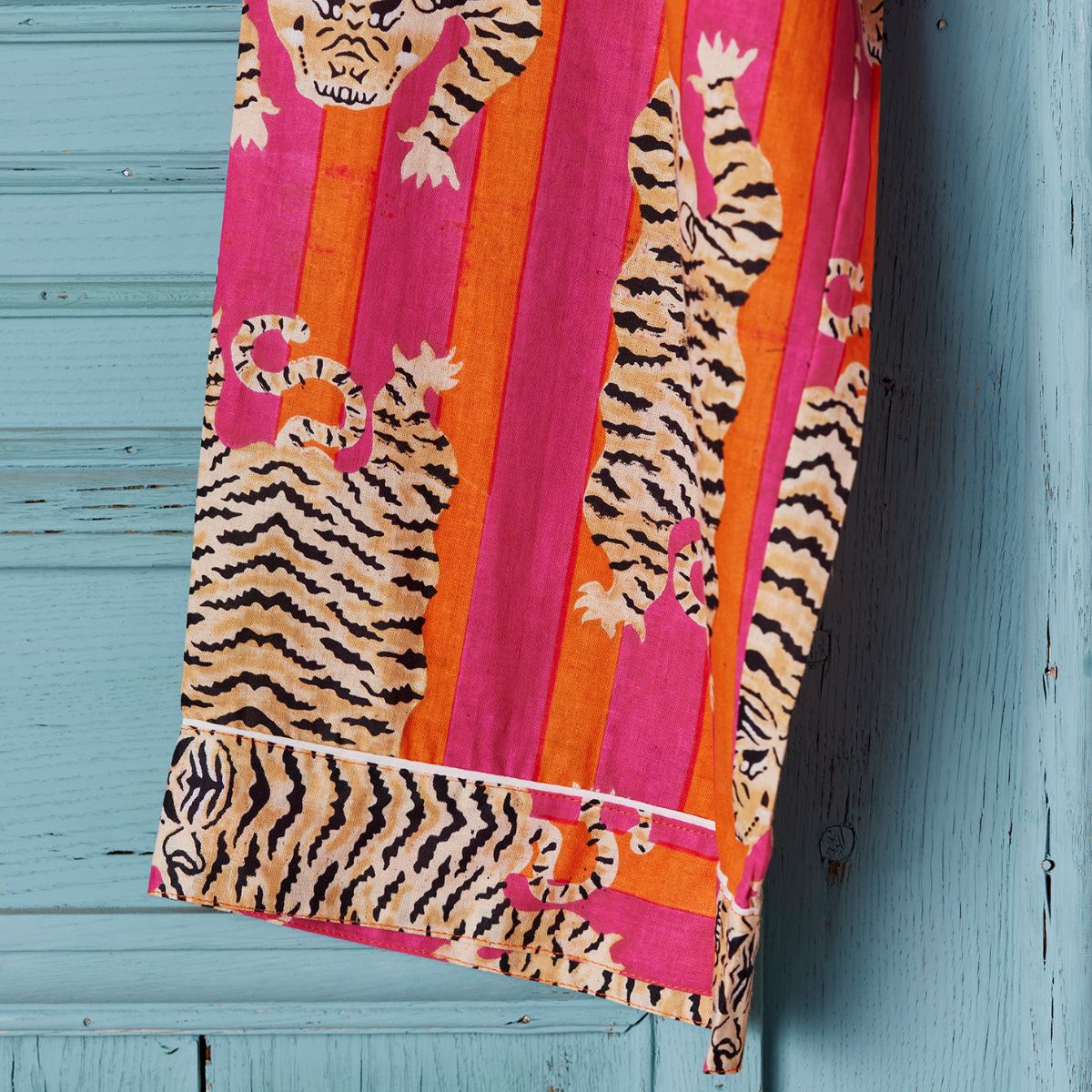Colorful towel with tiger design on a blue wooden surface