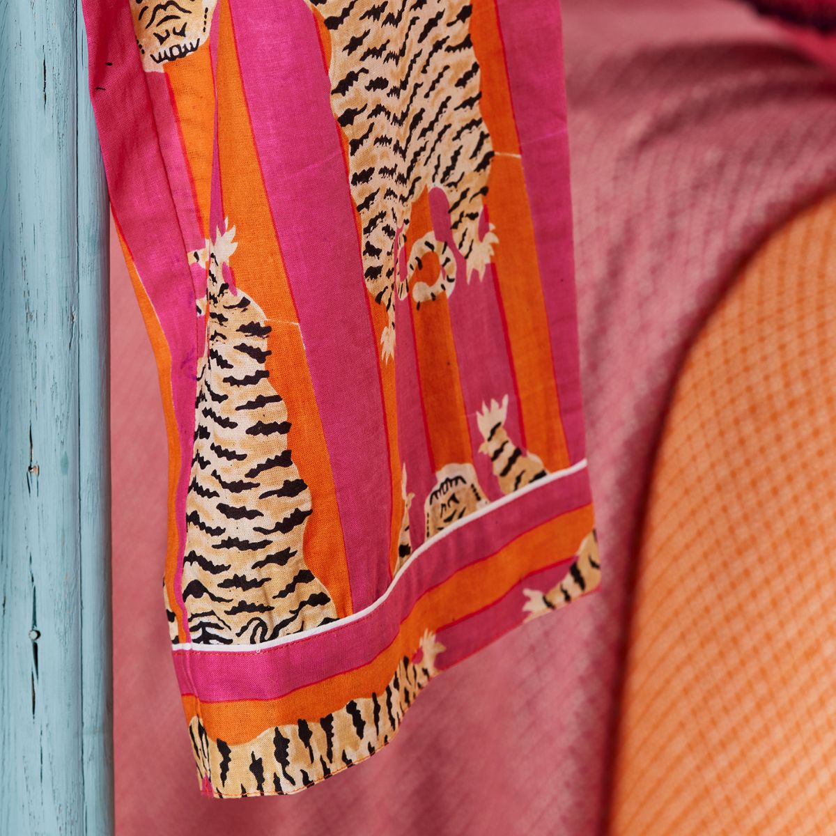 Colorful fabric with tiger pattern on a pink and orange background