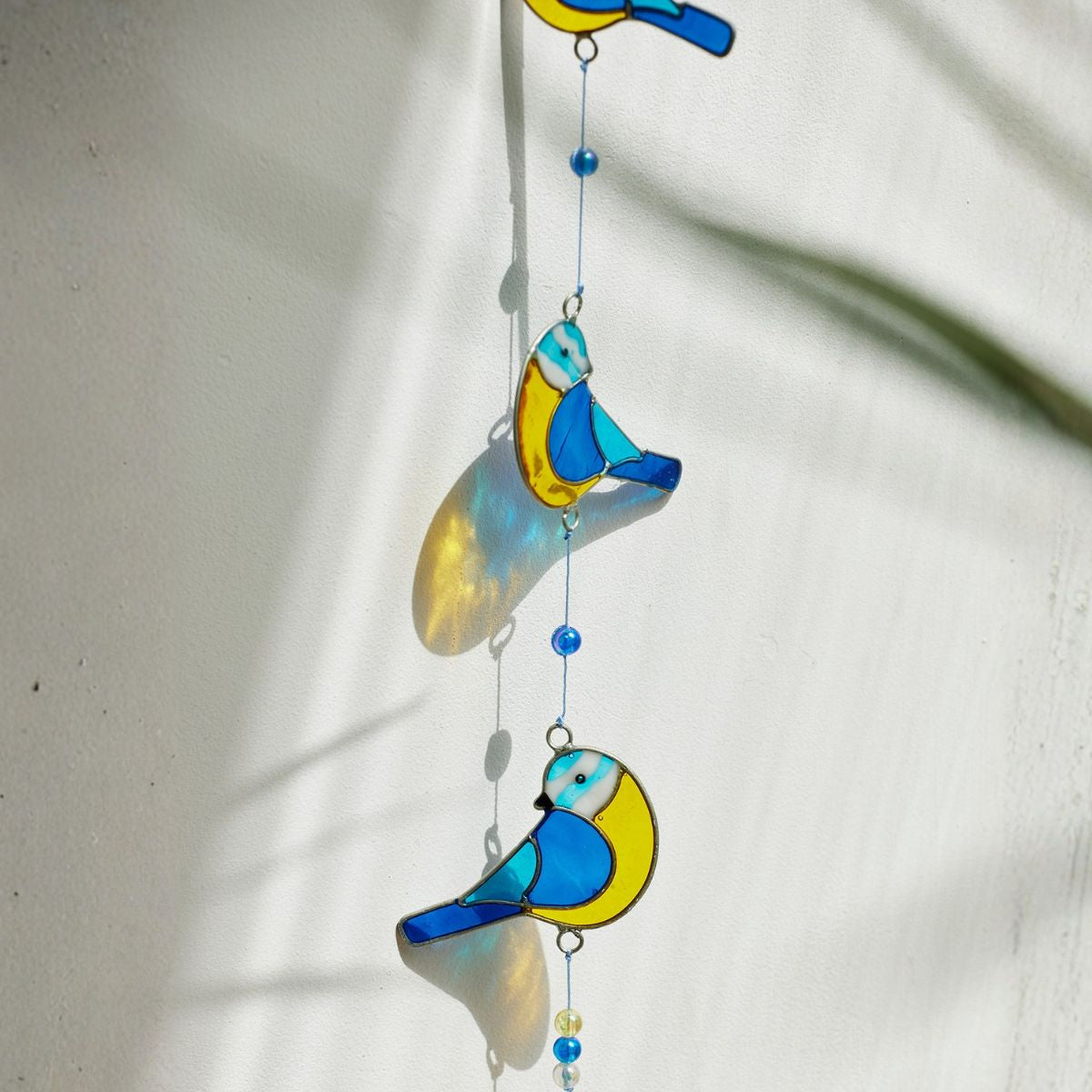 Decorative glass bird hanging on a white background