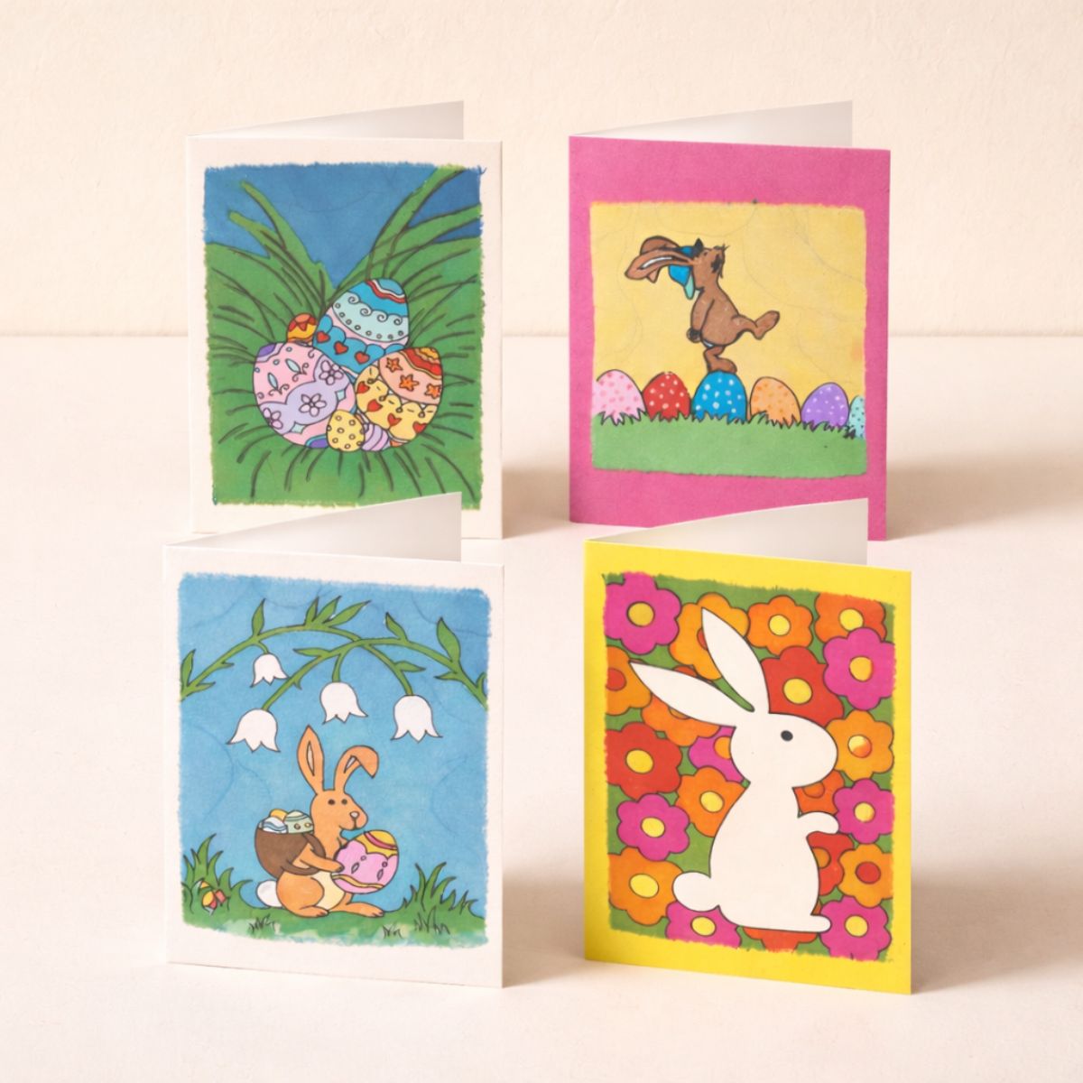Four colorful Easter-themed greeting cards on a light background