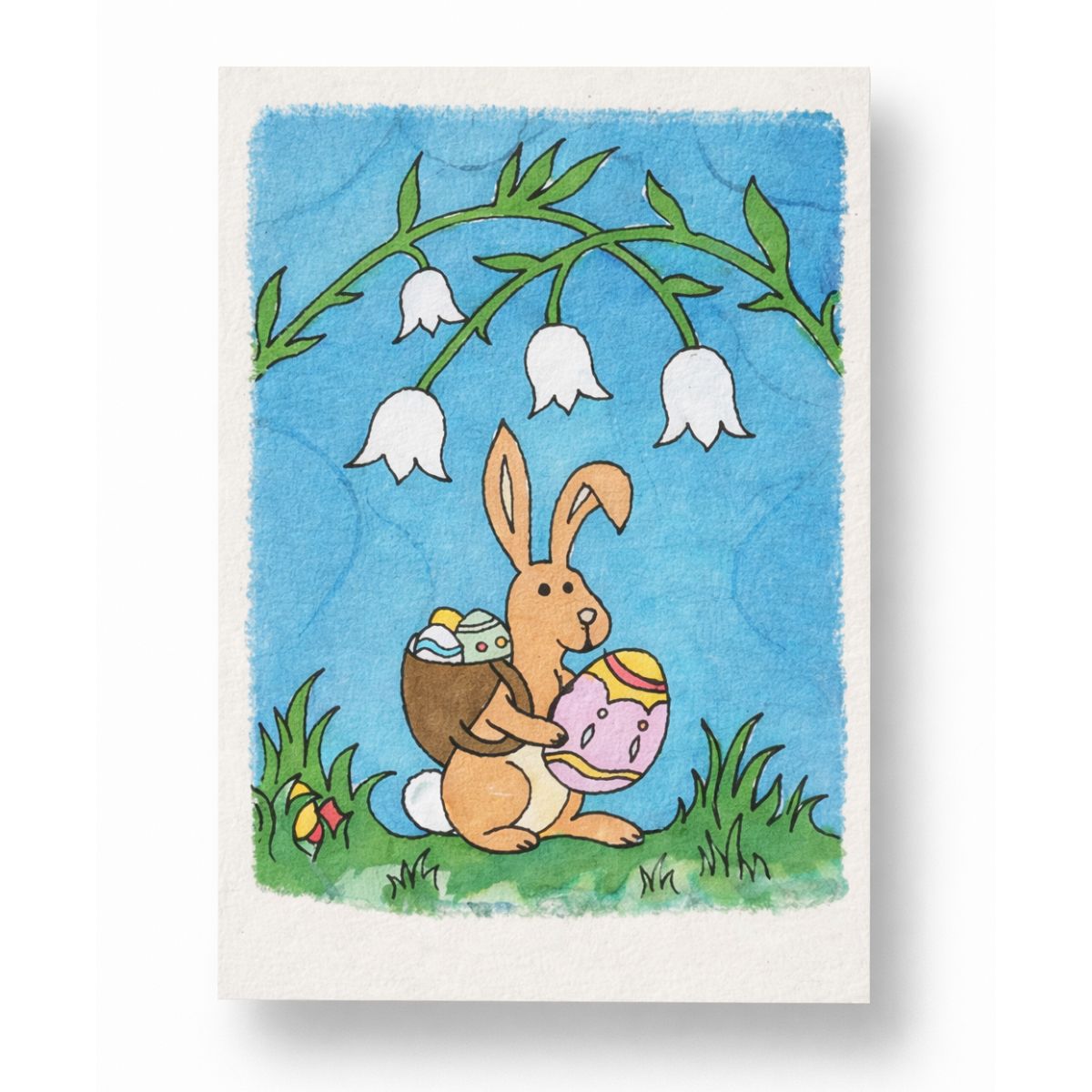 Card with an Easter design featuring a rabbit holding eggs and flowers on a blue background.