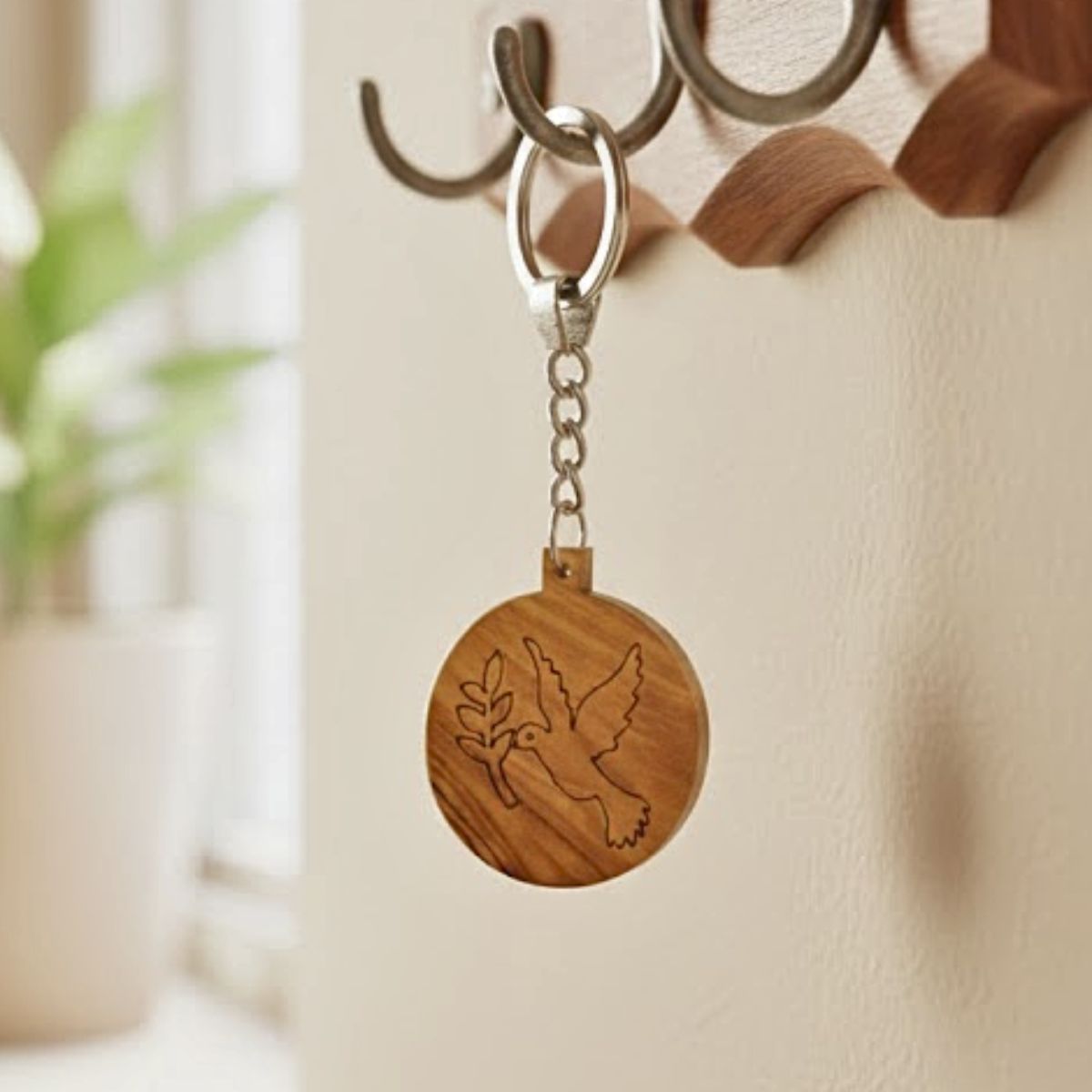 Wooden keychain with a dove design hanging on a hook