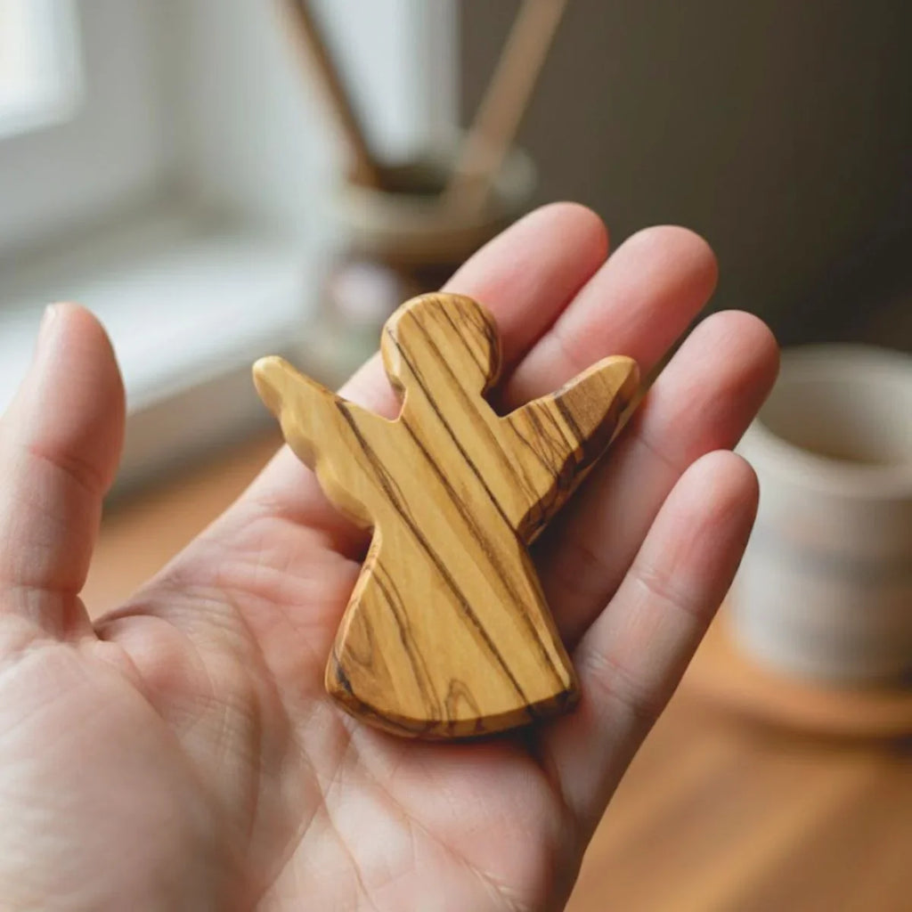 Wooden airplane-shaped object held in a hand with a blurred indoor background