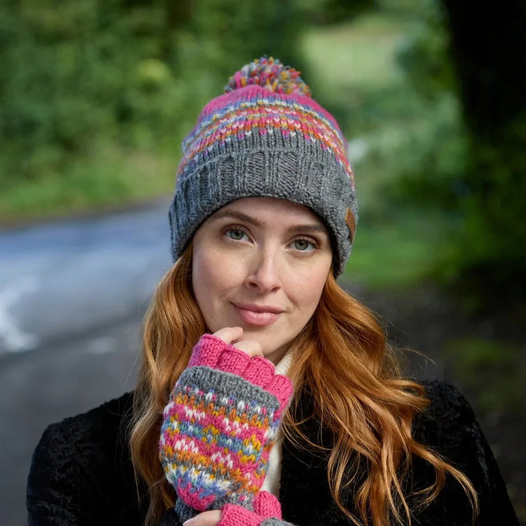 Woman wearing a colorful knit hat and mittens outdoors