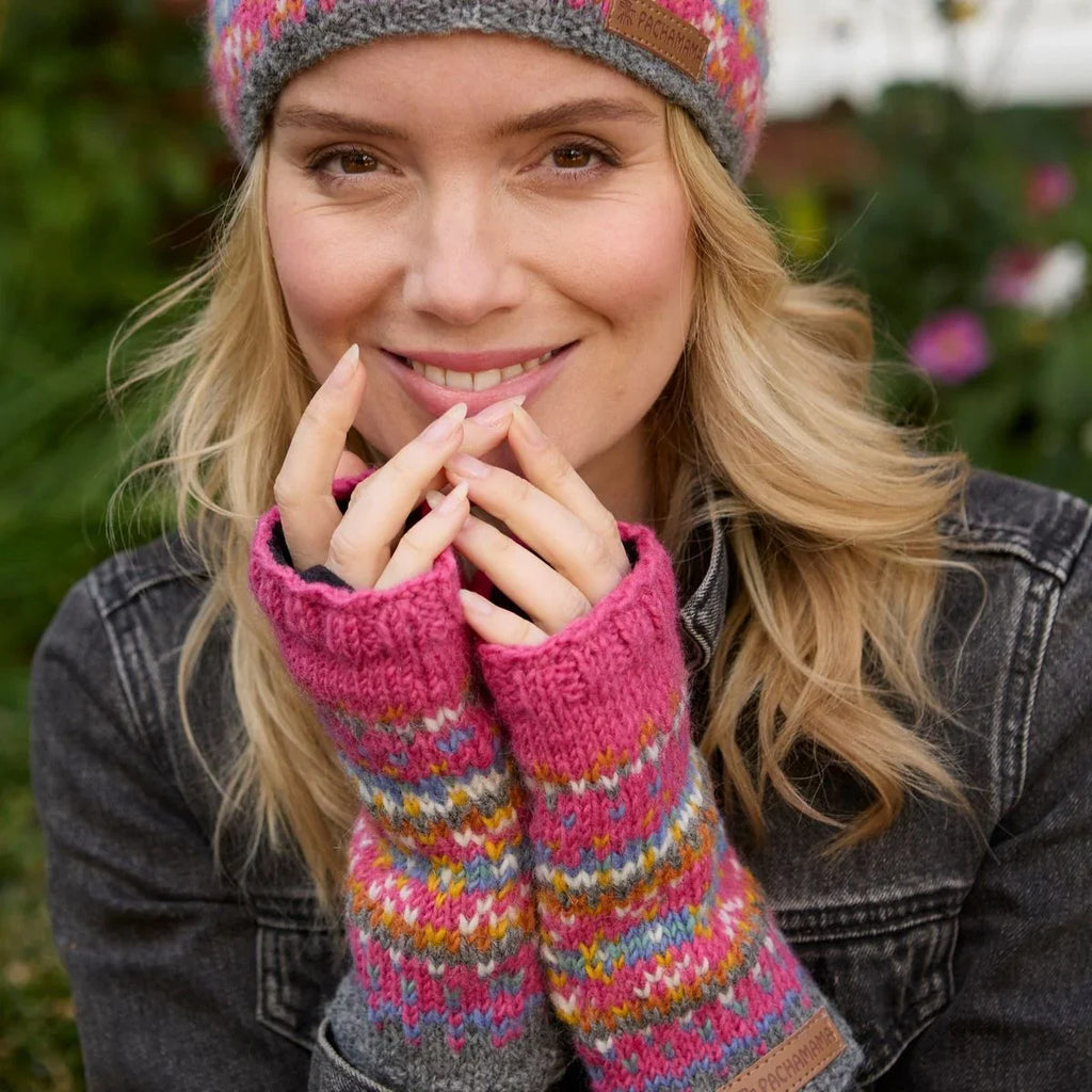 Woman wearing colorful knitted gloves and a matching hat with a blurred natural background