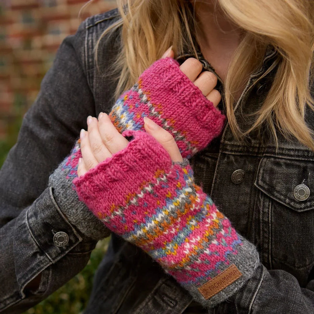 Person wearing colorful knitted fingerless gloves with a denim jacket.