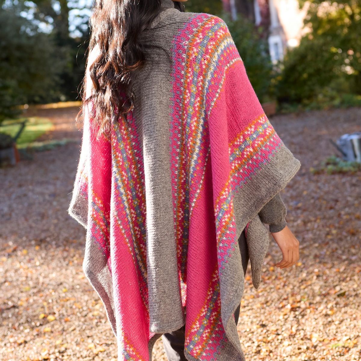 Person wearing a colorful poncho in an outdoor setting