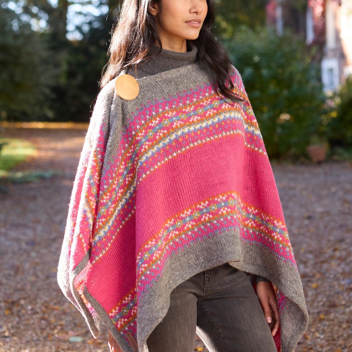 Woman wearing a colorful knitted poncho in an outdoor setting
