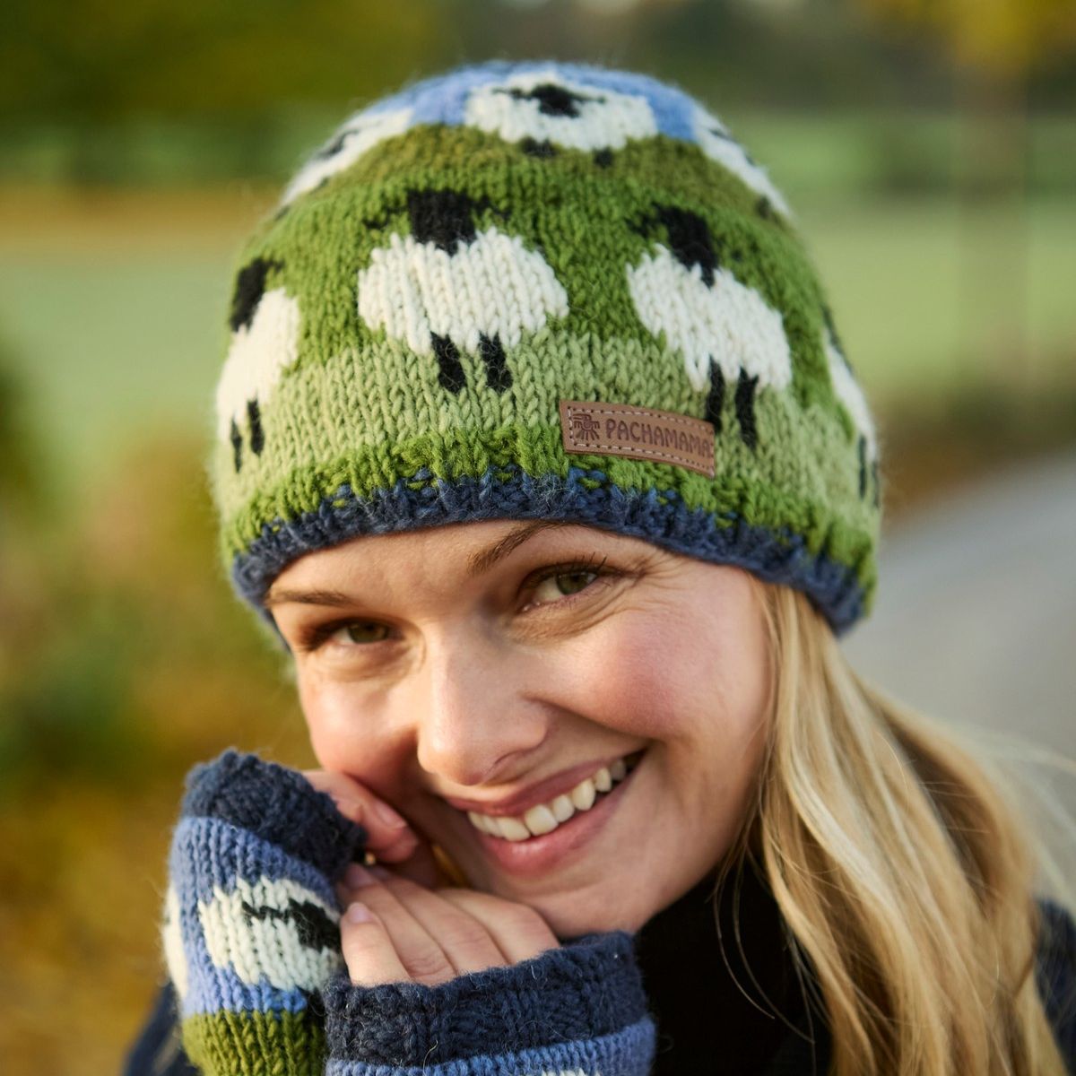 Woman wearing a knitted hat and gloves with sheep pattern outdoors