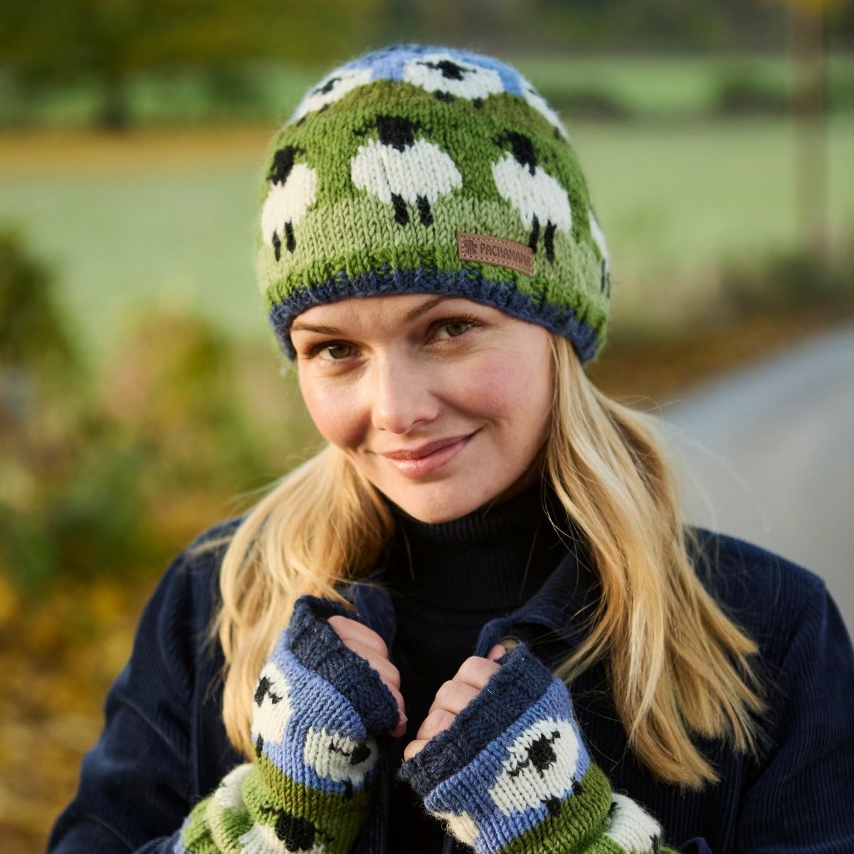 Woman wearing a knitted hat and gloves with sheep pattern outdoors