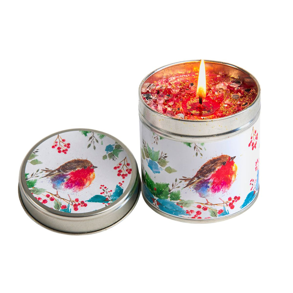 A decorative metal candle tin with a matching lid, shown open and lit on a white background. The tin and lid are printed with a watercolor robin bird and red berries motif on a white base, and the candle wax and wick are visible.