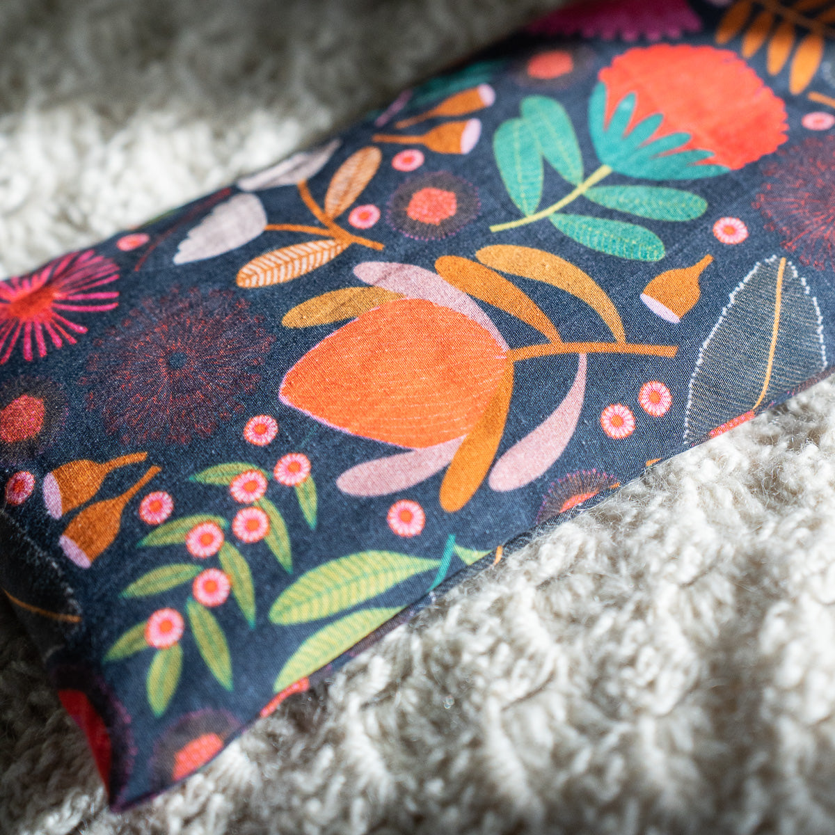 Decorative heat bag with floral pattern on a textured surface