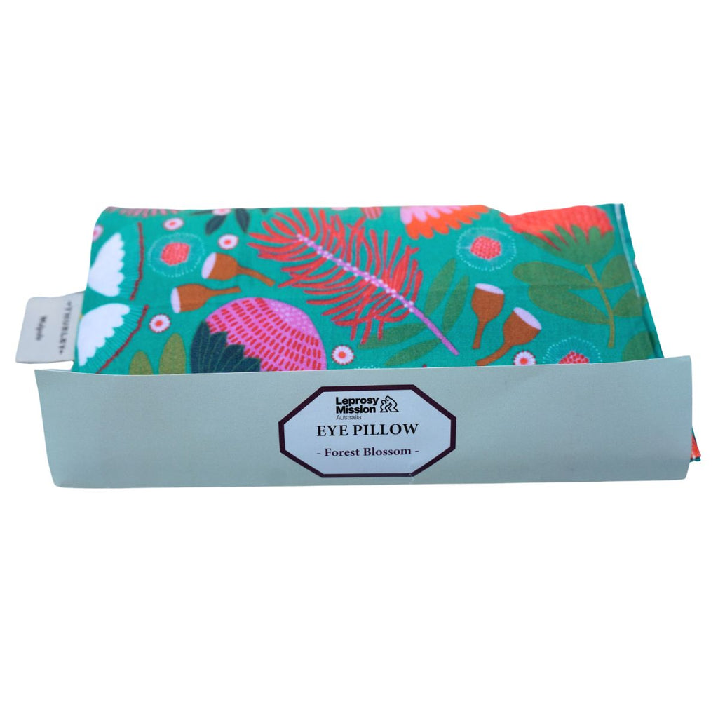 Eye pillow with floral design and brand label on a white background