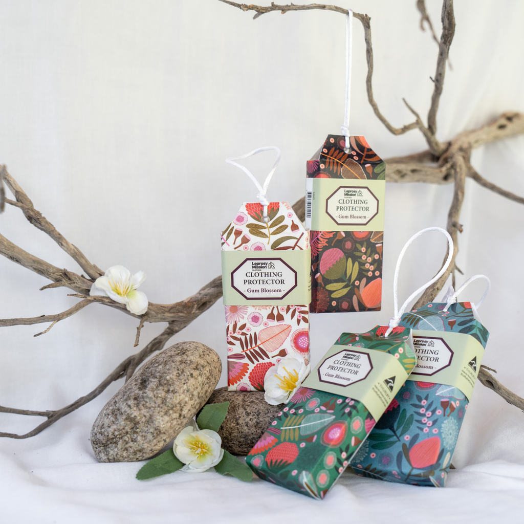Packaging of clothing protectors with floral designs on a white background with branches and flowers.