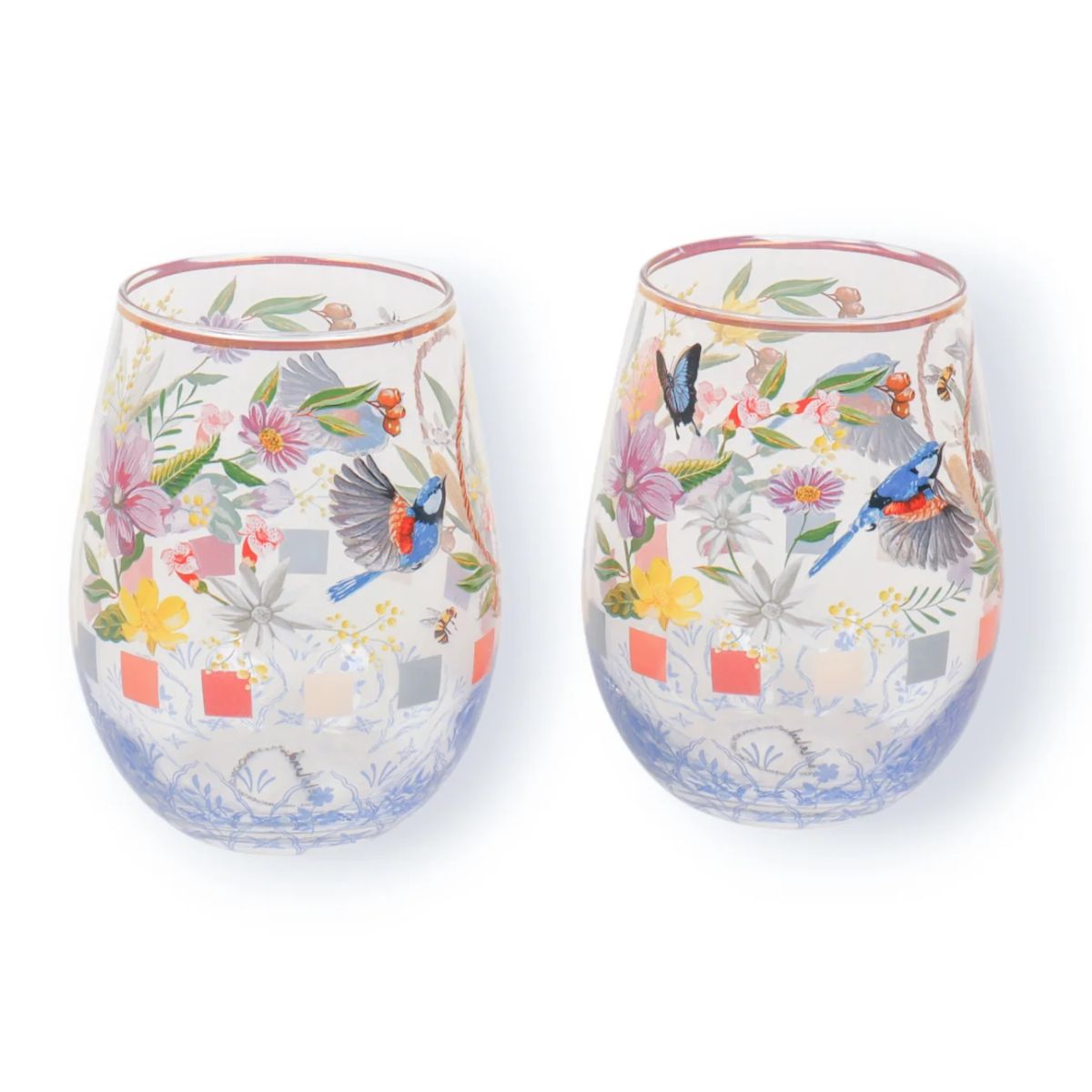 Two stemless wine glasses with floral and bird design on a white background