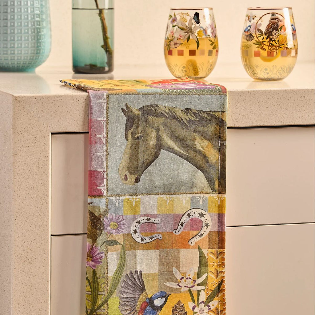 Decorative table runner with horse and floral design on a kitchen counter.