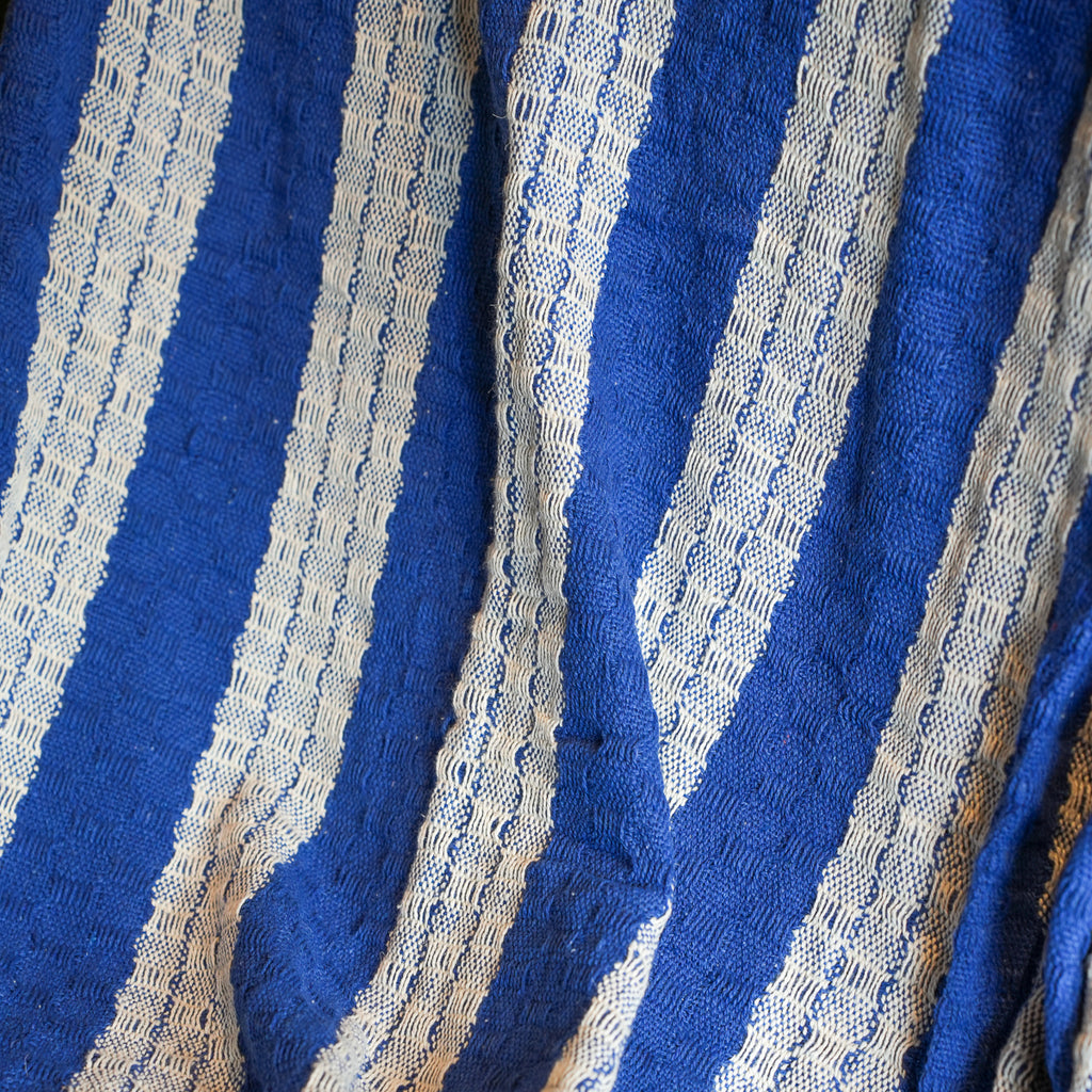 A close-up of a blue and off-white striped woven textile with a textured, ribbed pattern.